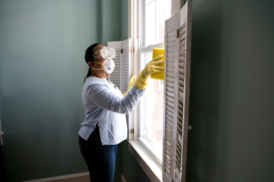 Housekeeper cleaning a window